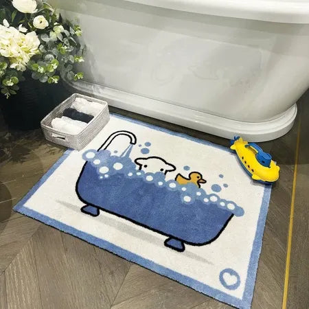 Hug Rug Bathtime Herdy doormat 50cm x 75cm displayed on bathroom floor next to bathtub, featuring white sheep character in blue bathtub with bubbles on cream and blue bordered mat, with bath toys and flowers visible