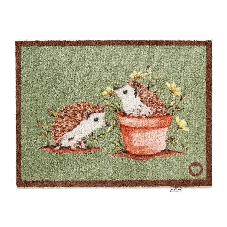 Hug Rug doormat featuring two hedgehogs with red and white quills among yellow flowers, one hedgehog in a terracotta pot, on sage green background with brown border, 65cm x 85cm