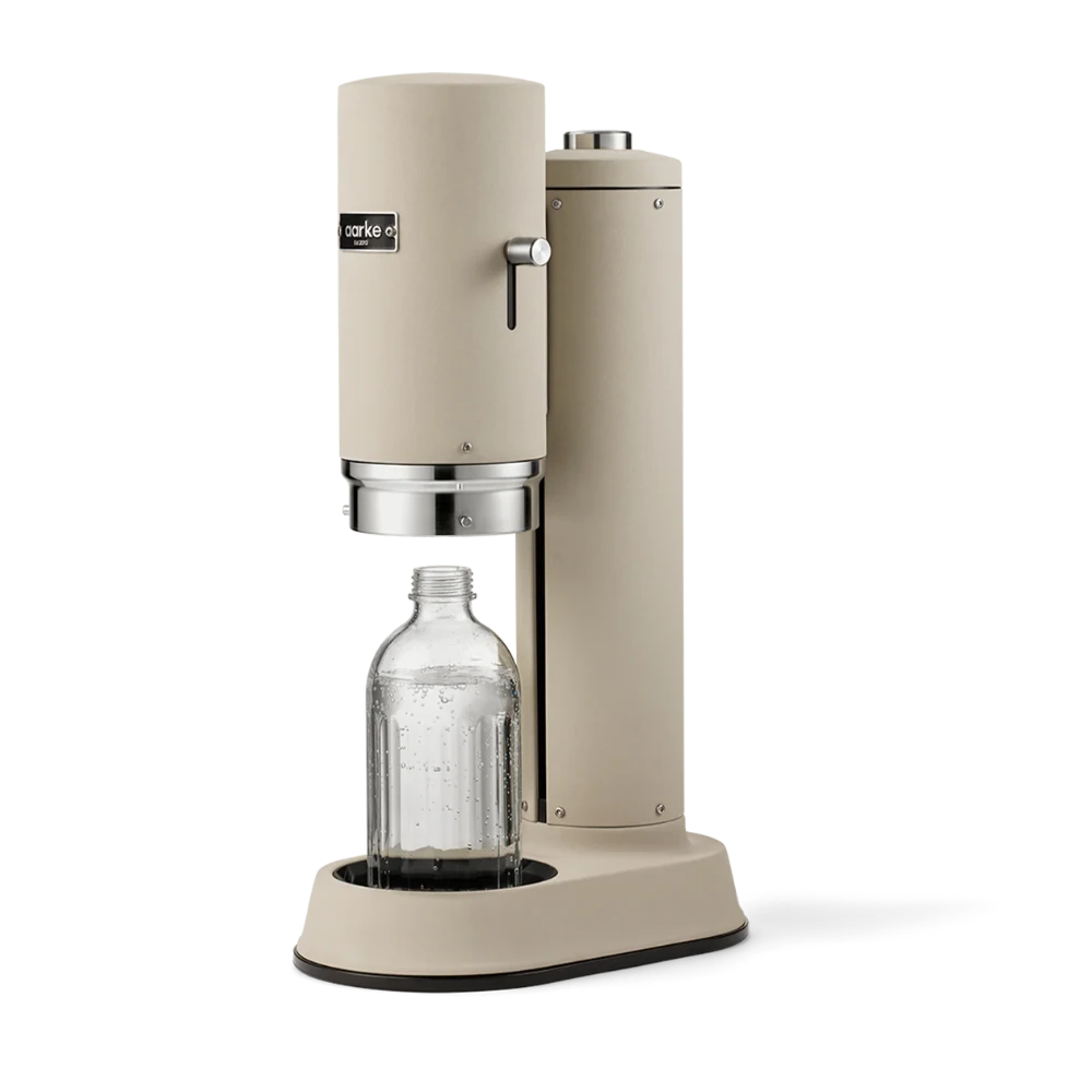 Beige carbonation machine with a clear bottle on a white background