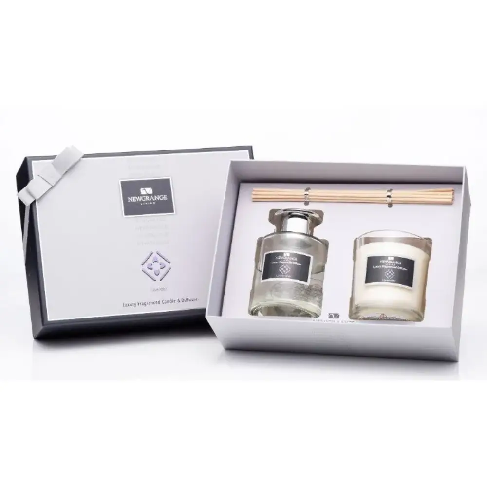 Newgrange Living Luxury Lavender Candle and Diffuser Set in white gift box containing glass diffuser bottle with silver cap, white scented candle, and wooden reed sticks with white ribbon bow