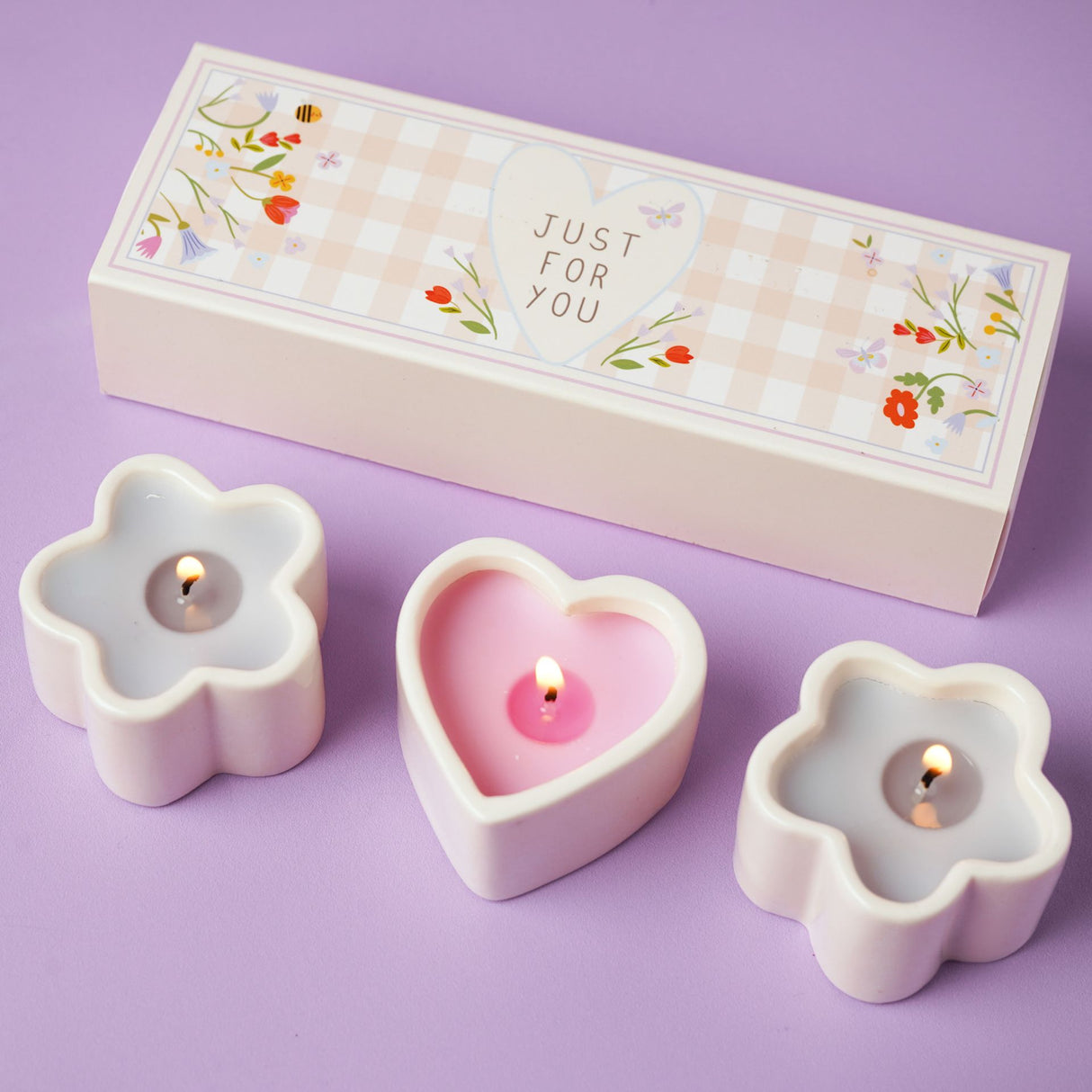 Flower-shaped candles with a 'Just For You' box on a purple background
