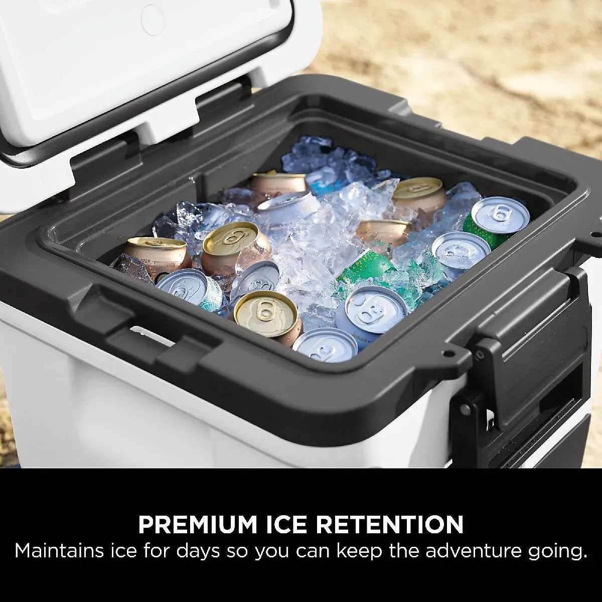 Ninja FrostVault 28 litre wheeled cooler with cloud white and black exterior filled with ice and beverages, showing premium ice retention feature with canned drinks and blue ice packs visible inside the black interior basin