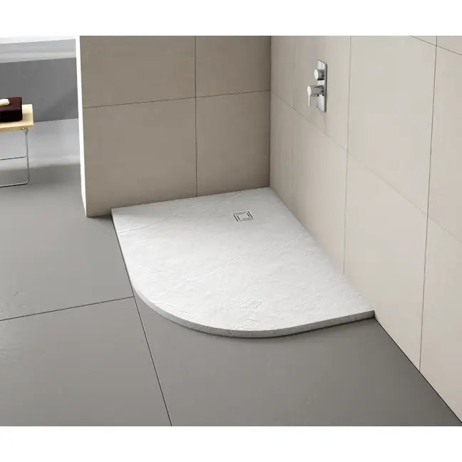 White curved quadrant Merlyn Truestone shower tray with integrated drain installed in modern minimalist bathroom with beige wall tiles and grey floor