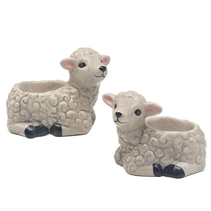 Two ceramic sheep planters with cream and white woolly textured bodies, pink inner ears, black hooves and facial features, displayed side by side against a white background