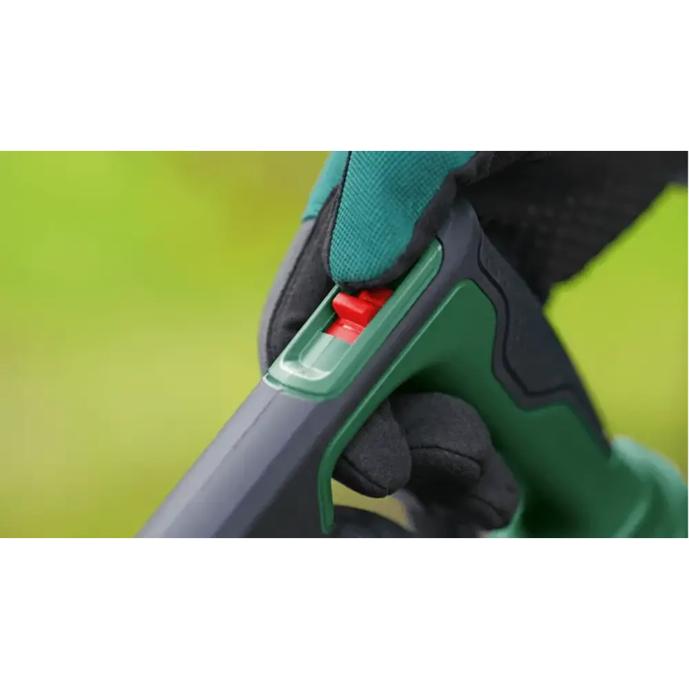 Close-up of Bosch Universal Garden Leaf Blower cordless handheld tool showing green and black grip handle with red trigger mechanism against bright yellow-green background, worn by gloved hand