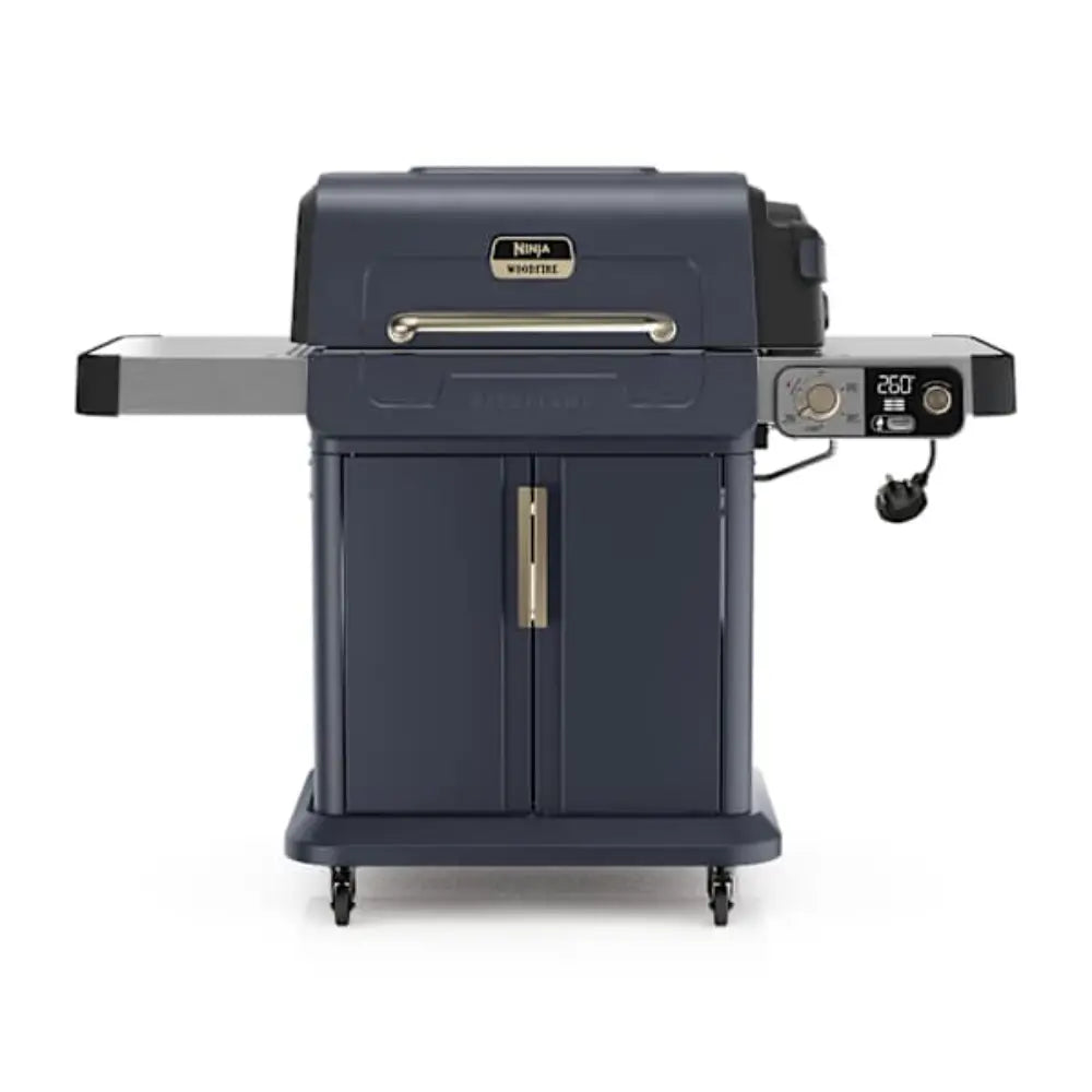 Ninja FlexFlame PG301UKBL gas barbecue grill in dark blue with stainless steel control panel displaying 260 temperature setting, featuring side shelves, front cart with wheels, and gold handles