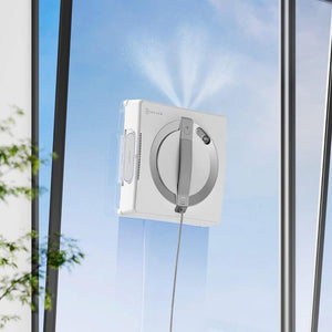 Window cleaning robot in front of a glass door with a clear blue sky.