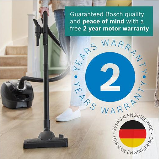 Person using a vacuum cleaner on a wooden floor with a Bosch warranty badge displayed.