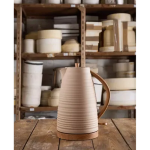 Morphy Richards Clay Felspar cream and brown ceramic jug kettle with wooden handle displayed on wooden surface against open shelving unit filled with kitchenware