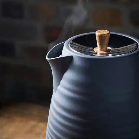 Morphy Richards Clay Flint grey jug kettle with wooden handle lid knob, steam rising from spout, textured ceramic body, 1.7 litre capacity