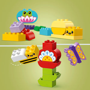 LEGO Creative Garden and Flowers set 10444 featuring colorful brick-built garden characters including a smiling frog on a lily pad, a yellow bee, a red flower with yellow center, purple butterfly, and various pastel-colored LEGO bricks in yellow, red, purple, green and blue arranged on a pale green background