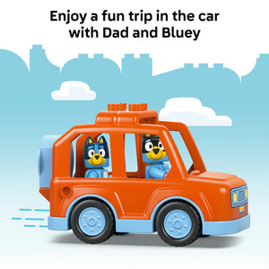 Orange and blue LEGO Duplo toy car with Bluey and Bingo figures inside, set against a blue sky background with white clouds and cityscape silhouette