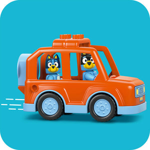 LEGO Bluey orange and light blue vehicle toy set featuring Bluey and Bingo characters in windows against turquoise background with roof-mounted cargo containers