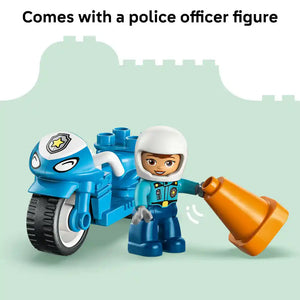 LEGO Duplo blue police motorcycle set featuring a smiling police officer minifigure in white helmet and blue uniform with a blue motorcycle toy and orange traffic cone against a light green castle backdrop