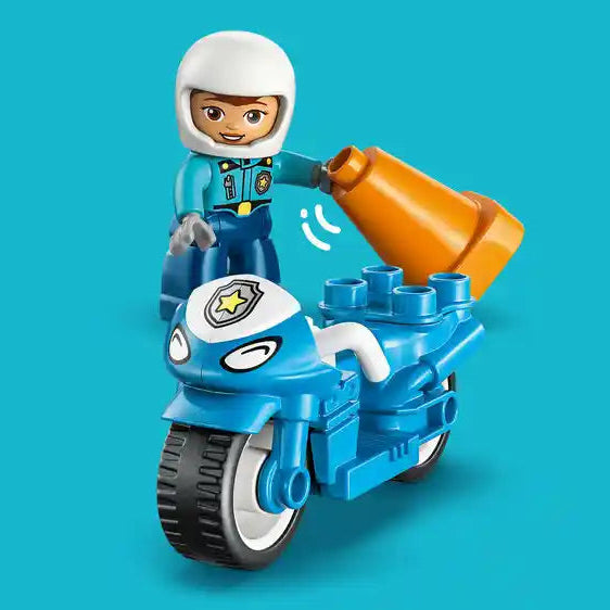 LEGO Duplo blue police motorcycle with white-helmeted officer figure, orange siren light, and black wheels on turquoise background