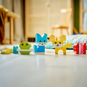 LEGO DUPLO My First 3 in 1 Creative Cute Pets set featuring colorful block-built animal characters including a green smiling frog, blue cat, and yellow mouse with red gift box on white floor in playroom setting