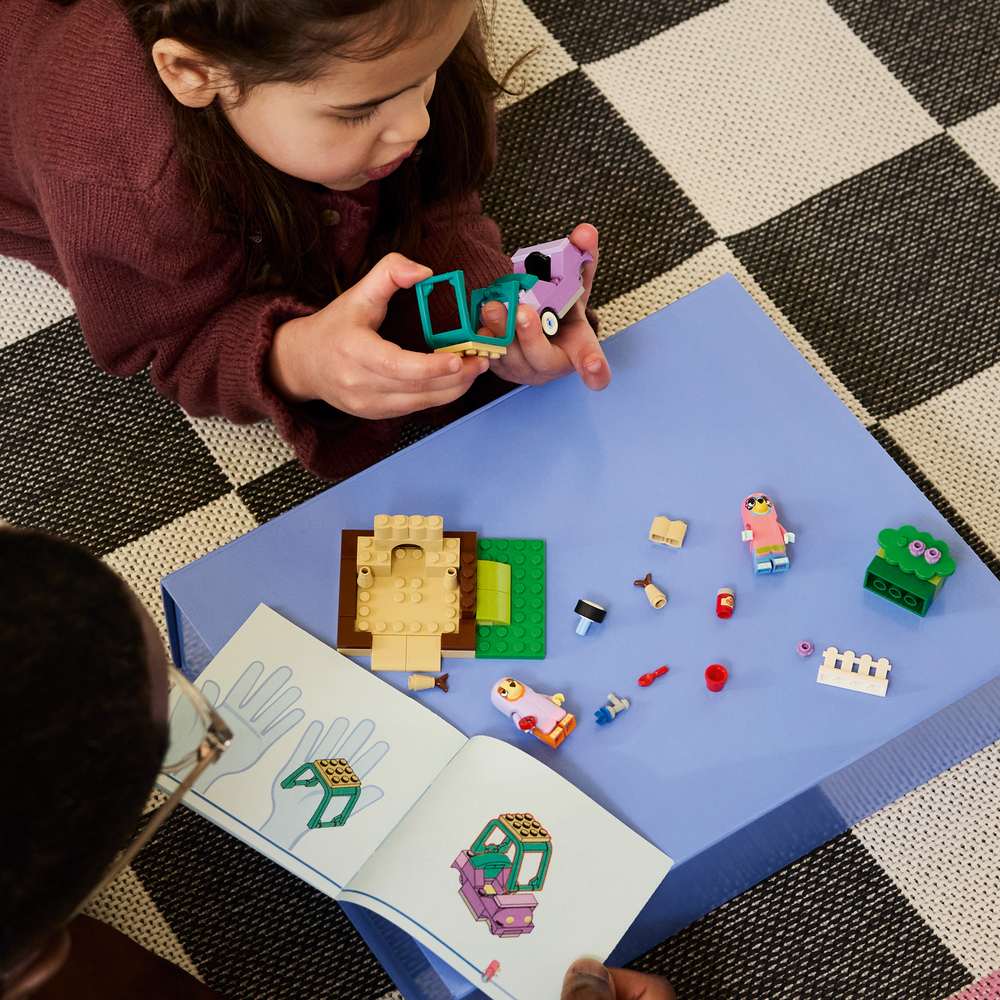 LEGO Bluey Grannies with Bingo and Bluey 11216 - a child building the set. 80 pieces. Ages 4+.