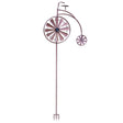 Purple metal penny farthing bicycle wind spinner with large front wheel and small rear wheel, featuring solar-powered design with ground stake base
