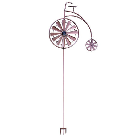 Purple metal penny farthing bicycle wind spinner with large front wheel and small rear wheel, featuring solar-powered design with ground stake base