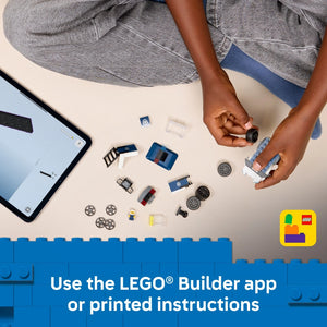 Overhead flat lay of LEGO 60481 Police Truck set components including blue and white brick pieces, minifigure, wheels, and other small parts arranged on a white surface with a child's hands assembling pieces, alongside a smartphone showing the LEGO Builder app, with blue LEGO brick border and app logo in bottom right corner