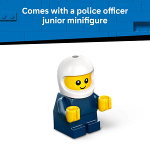A bright yellow smiling LEGO minifigure wearing a white police helmet and dark blue uniform with yellow hands, standing against a blue LEGO brick background with text reading "Comes with a police officer junior minifigure"