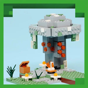 LEGO Minecraft Pale Garden set featuring a grey tower structure with orange glowing orbs, white and green base platform with grass, flowers, plants, and a brown chest, displayed against light blue background with green border