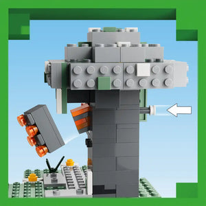 LEGO Minecraft The Pale Garden set 21586 featuring a gray blocky creeper figure with orange rocket launcher, surrounded by green grass base plates, gray stone bricks, and various LEGO elements against a light blue sky background