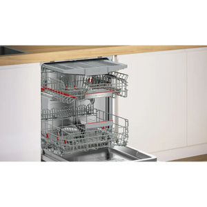 Bosch Series 6 integrated dishwasher with stainless steel interior and red handles, partially open showing upper and lower wire baskets, installed under wooden countertop in modern white kitchen cabinetry