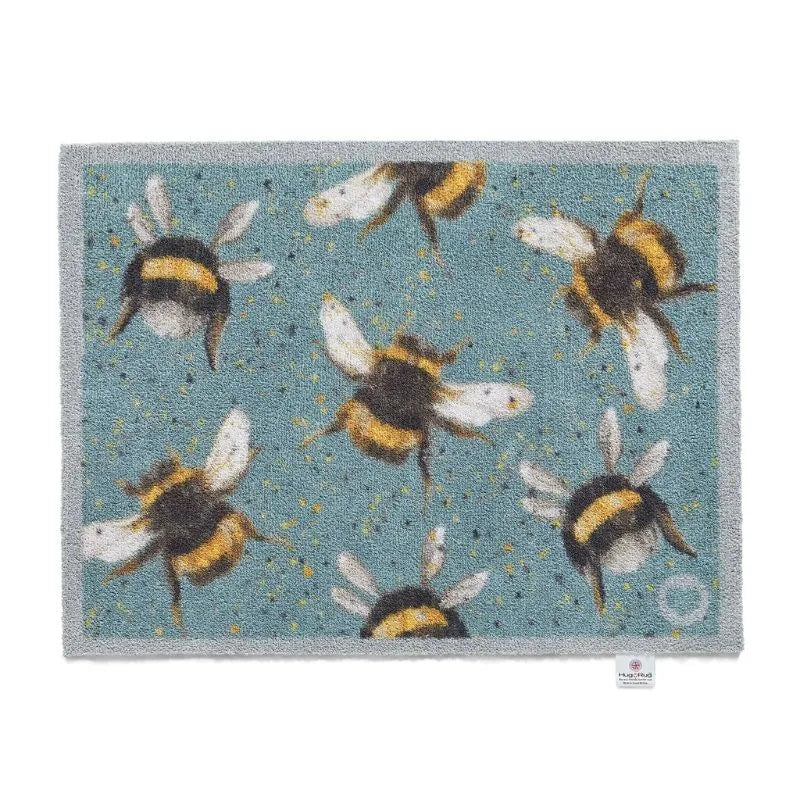 Hug Rug doormat with bee pattern featuring multiple bumblebees in yellow, black and white on a teal blue background, 65cm x 85cm size