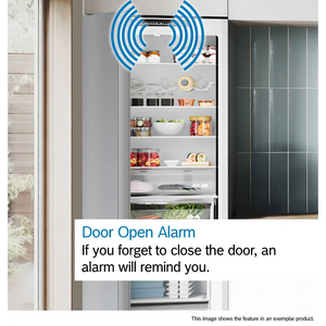 Bosch Series 2 white fridge freezer with door open alarm feature illustrated by blue sound wave icon, showing organized shelves with fresh produce, condiments and kitchenware, modern kitchen setting with dark green cabinetry visible to the right