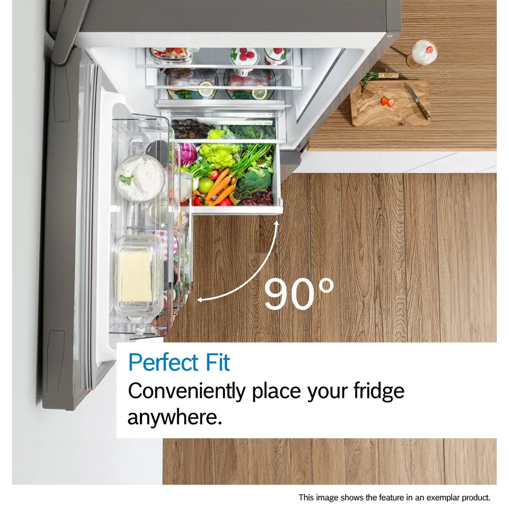 Overhead view of Bosch Series 2 fridge freezer with 90-degree opening angle showing fully stocked interior with fresh vegetables, dairy products and frozen items, displaying Perfect Fit feature on wooden kitchen countertop next to cutting board with fresh ingredients
