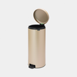 Brabantia 30 litre New Icon champagne coloured pedal bin with stainless steel lid and black foot pedal on light background