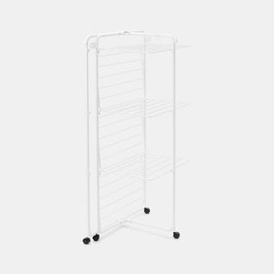 White metal clothes airer with multiple horizontal drying rails, three shelves, and black caster wheels on a light background