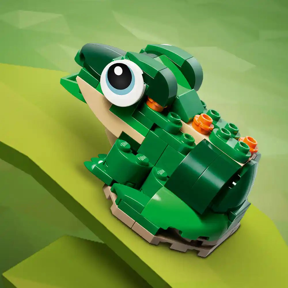 LEGO Creator green turtle buildable toy with large expressive eyes, tan belly details, and orange flower accents, displayed on layered yellow-green background