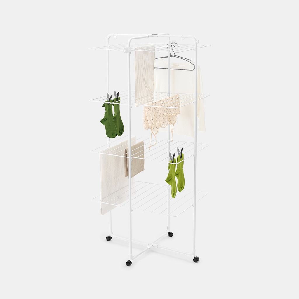 White metal tower clothes airer with multiple horizontal drying rails displaying green gloves, beige towels, a striped cloth, and a black hanger, featuring casters for mobility