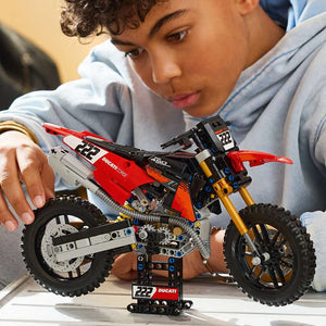 LEGO Technic Ducati Desmo450 MX Factory Motorcycle 42238 - a child playing with the finished build. 457 pieces. Ages 10+.