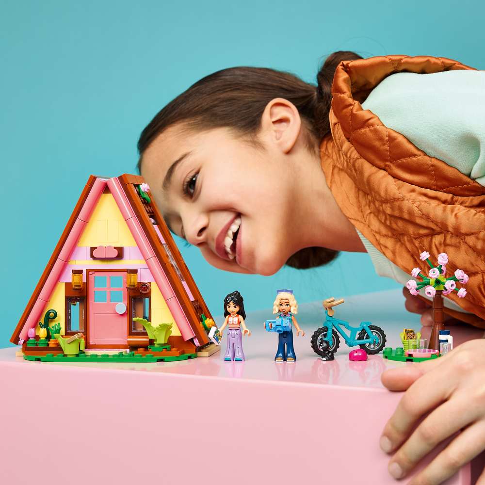 LEGO Friends Nature Glamping Cabin 42682 - a child playing with the finished build. 295 pieces. Ages 6+.