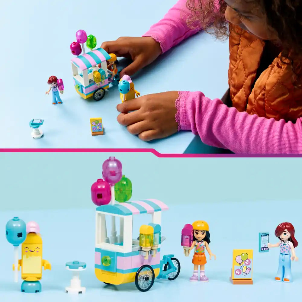 Child playing with LEGO Friends ice cream cart set 42692 featuring colorful pastel ice cream stand with pink and turquoise striped awning, minifigures, ice cream cones, balloons, and accessories displayed on light blue background