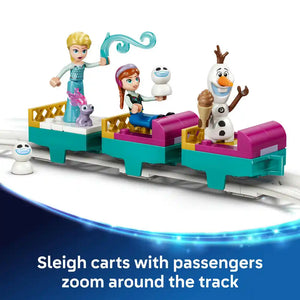 LEGO Disney Frozen ice castle playset featuring Elsa minifigure with turquoise magic staff, Anna with snowman Olaf, and three turquoise and magenta sleigh carts on white track with small snowball character figures