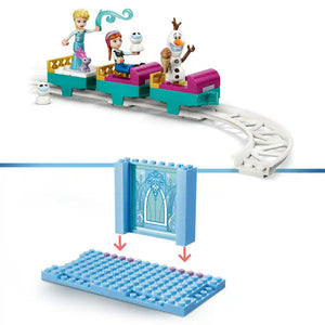LEGO Elsa's Ice Castle Snow Ride Adventure set 43281 featuring turquoise and magenta train cars with Elsa and Anna minifigures, Olaf snowman character, blue castle gate backdrop with snowflake design, and connecting track pieces on white baseplate