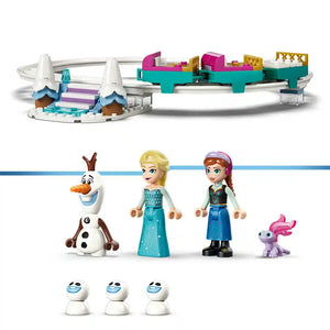LEGO Disney Frozen set 43281 featuring turquoise and white ice castle track with pink and gold roofs, minifigures of Elsa in blue dress and Anna in green jacket, Olaf snowman character, small purple animal figure, and three snowball pieces displayed against white background