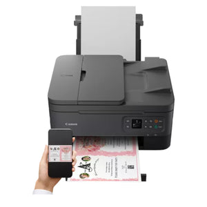 Canon PIXMA TS7450I black wireless all-in-one multifunction printer with automatic document feeder, shown with printed photo output and mobile phone displaying Canon printing app