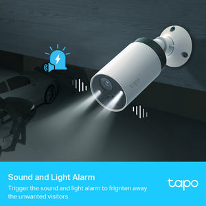 TP-Link Tapo white cylindrical security camera mounted on wall with spotlight beam illuminating parked car below, featuring sound and light alarm icons and demonstrating motion detection capabilities