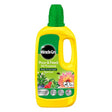 Miracle-Gro Pour and Feed All Purpose ready-to-use liquid plant food in a bright yellow plastic bottle with green cap and handle, featuring product labeling and images of flowering plants