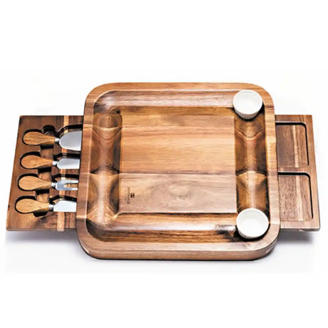 Newgrange Living wooden cheese board set with rectangular acacia wood serving tray, four stainless steel cheese knives with wooden handles, two white ceramic bowls, and side storage compartments for utensil organization