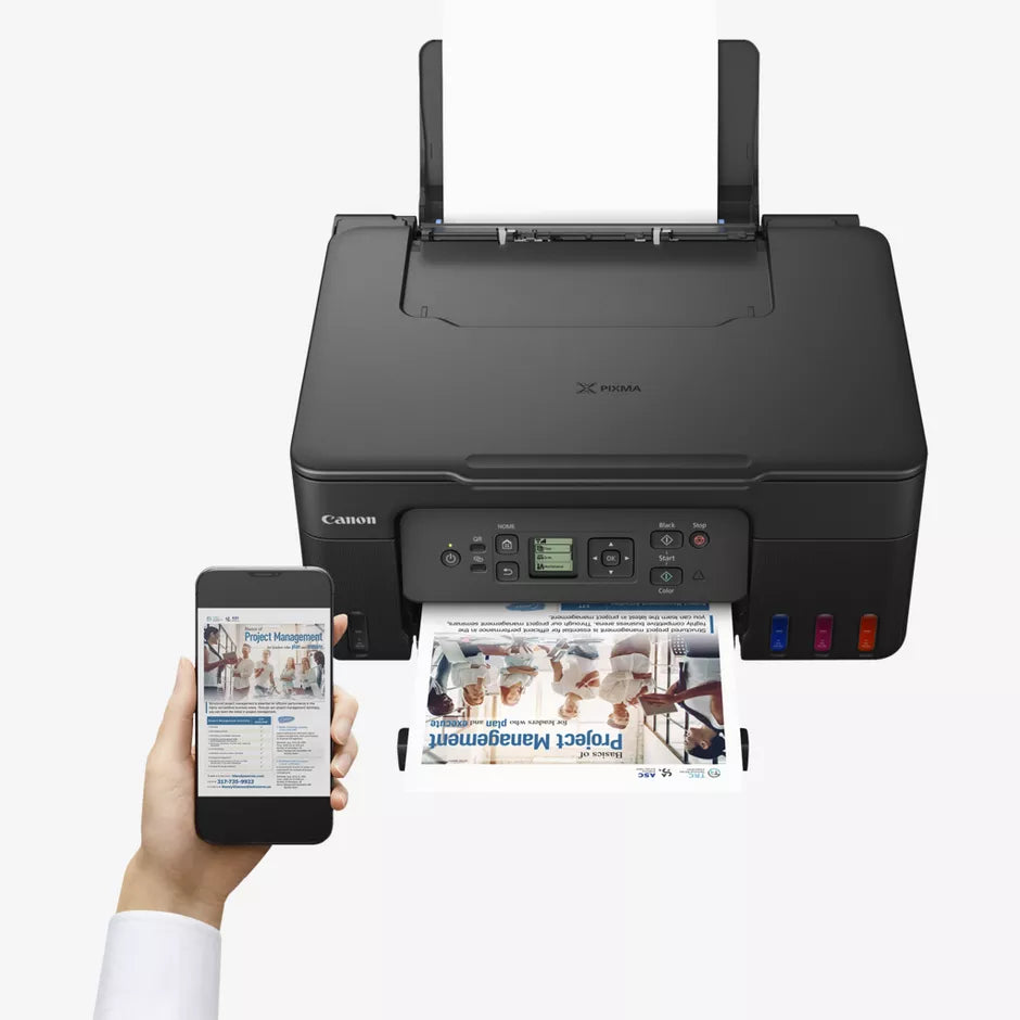 Canon printer printing a document with a hand holding a smartphone displaying a webpage.