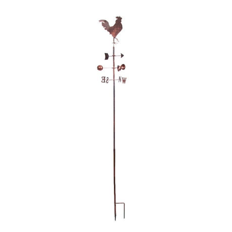 Rustic copper rooster weather vane with directional cardinal points (N, S, E, W) mounted on tall metal pole with ground stake