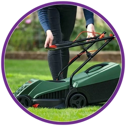 Person using a green lawn mower on grass
