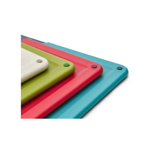 Four colorful Joseph Joseph Folio chopping boards stacked in white, lime green, coral red, and teal blue with textured surfaces and gray corner pegs, displayed in a 3D perspective view
