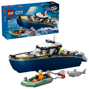 LEGO City Police Boat Chase set 60456 featuring a dark blue and yellow police boat with white cabin, minifigures, green inflatable rescue raft, shark figure, and product packaging against white background